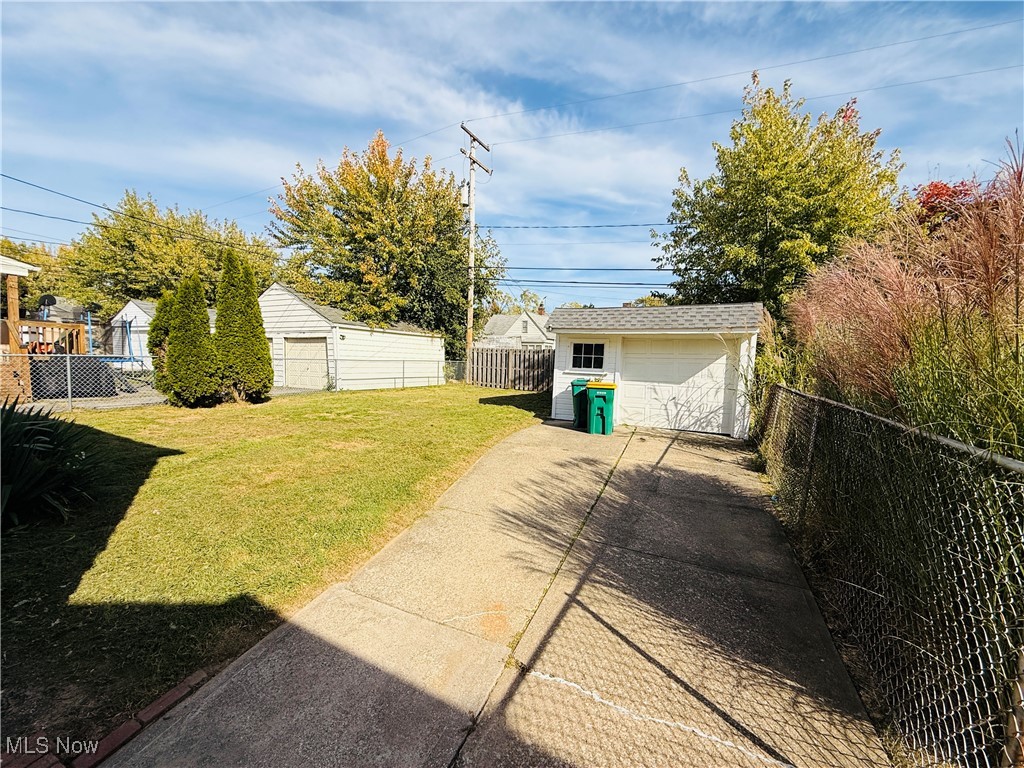 5239 Arch Street Maple Heights, OH 44137 - Photo 23 of 25 Fenced backyard featuring an outbuilding, a detached garage, and concrete driveway