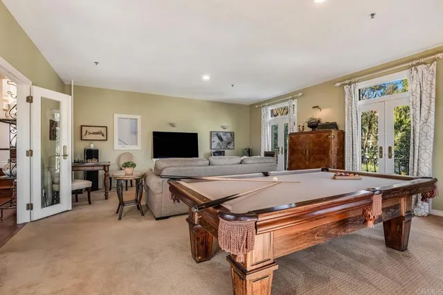 a room with furniture pool table and flat screen tv