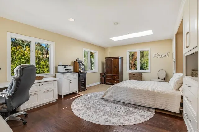 a spacious bedroom with a bed a couch and a flat tv screen in it