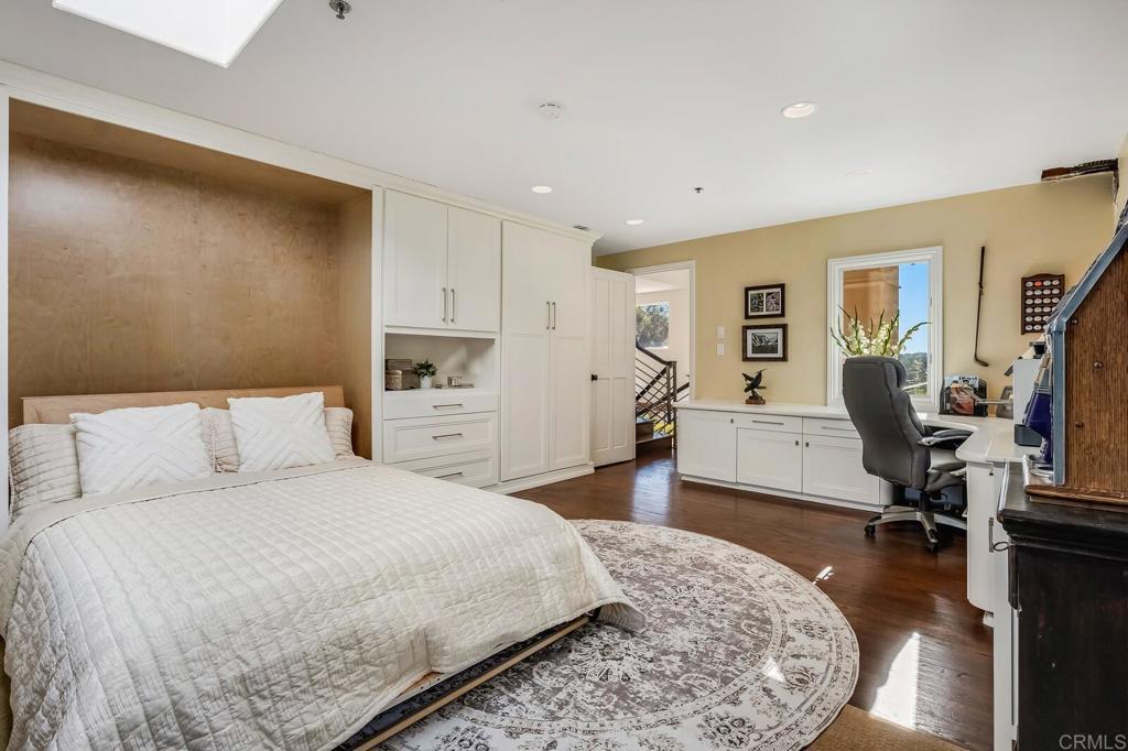 136 Hummingbird Hill Encinitas, CA 92024 - Photo 26 of 54 a spacious bedroom with a bed a couch and a flat tv screen in it