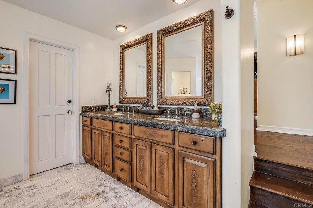 136 Hummingbird Hill Encinitas, CA 92024 - Photo 33 of 54 a bathroom with a granite countertop sink and a mirror
