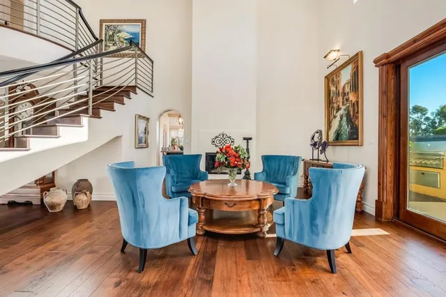 a dining room with furniture wooden floor a painting and a chandelier