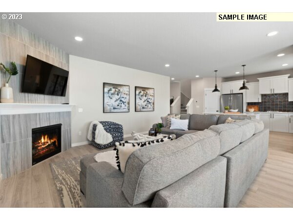 231 South 87th Avenue Ridgefield, WA 98642 - Photo 16 of 33 a living room with furniture a fireplace and a flat screen tv