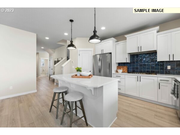 231 South 87th Avenue Ridgefield, WA 98642 - Photo 6 of 33 a kitchen with stainless steel appliances kitchen island a table chairs sink and cabinets