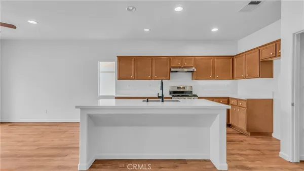 a kitchen with stainless steel appliances a sink stove and cabinets