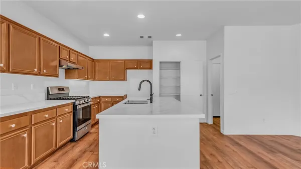 a kitchen with sink a stove and cabinets