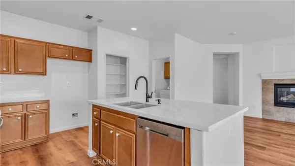 a view of a sink and dishwasher with wooden floor