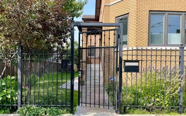 a view of a house with a small yard and wooden fence