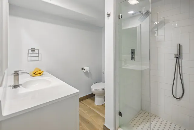 a bathroom with a granite countertop sink a toilet and shower