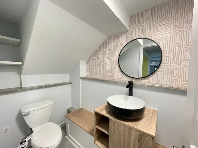 a bathroom with a toilet a sink and mirror