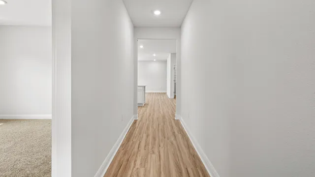 a view of a hallway with wooden floor