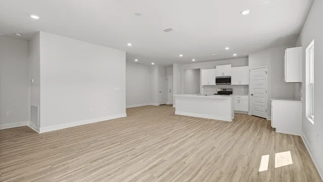 a view of a kitchen with wooden floor and electronic appliances