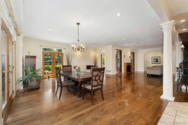 a view of a dining room and livingroom with furniture wooden floor a chandelier
