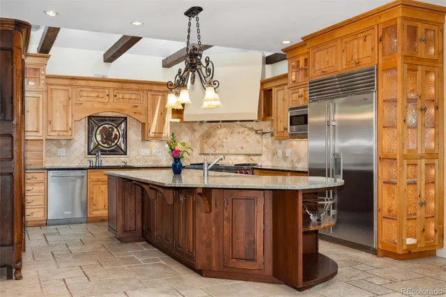 a kitchen with stainless steel appliances granite countertop a sink and a refrigerator