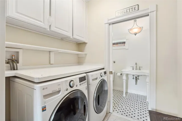 a utility room with cabinets washer and dryer
