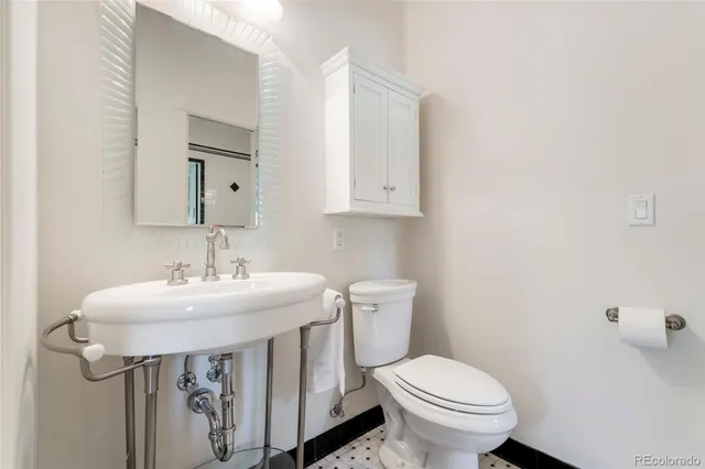 a bathroom with a sink toilet and mirror
