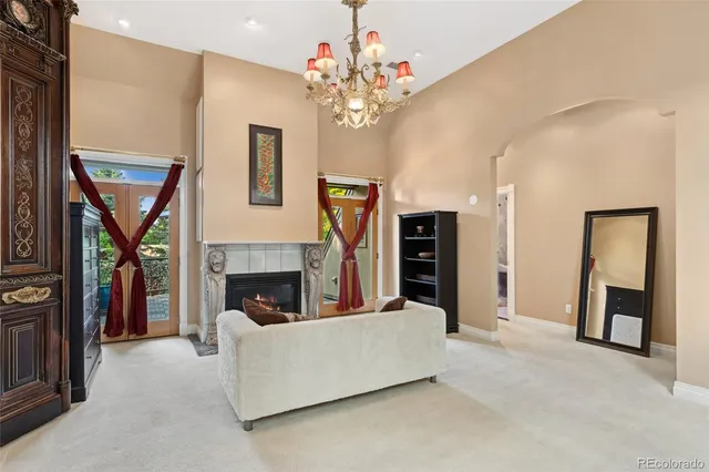 a living room with furniture a fireplace and a chandelier