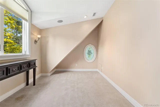 a view of a workspace with furniture and a window
