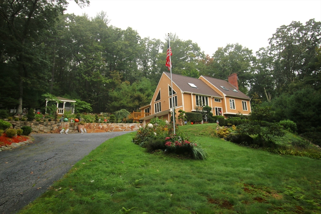 a front view of a house with swing and a garden