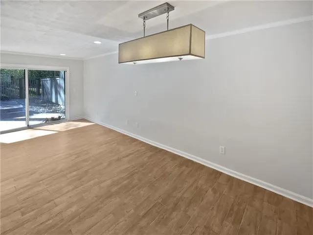 an empty room with wooden floor and fireplace
