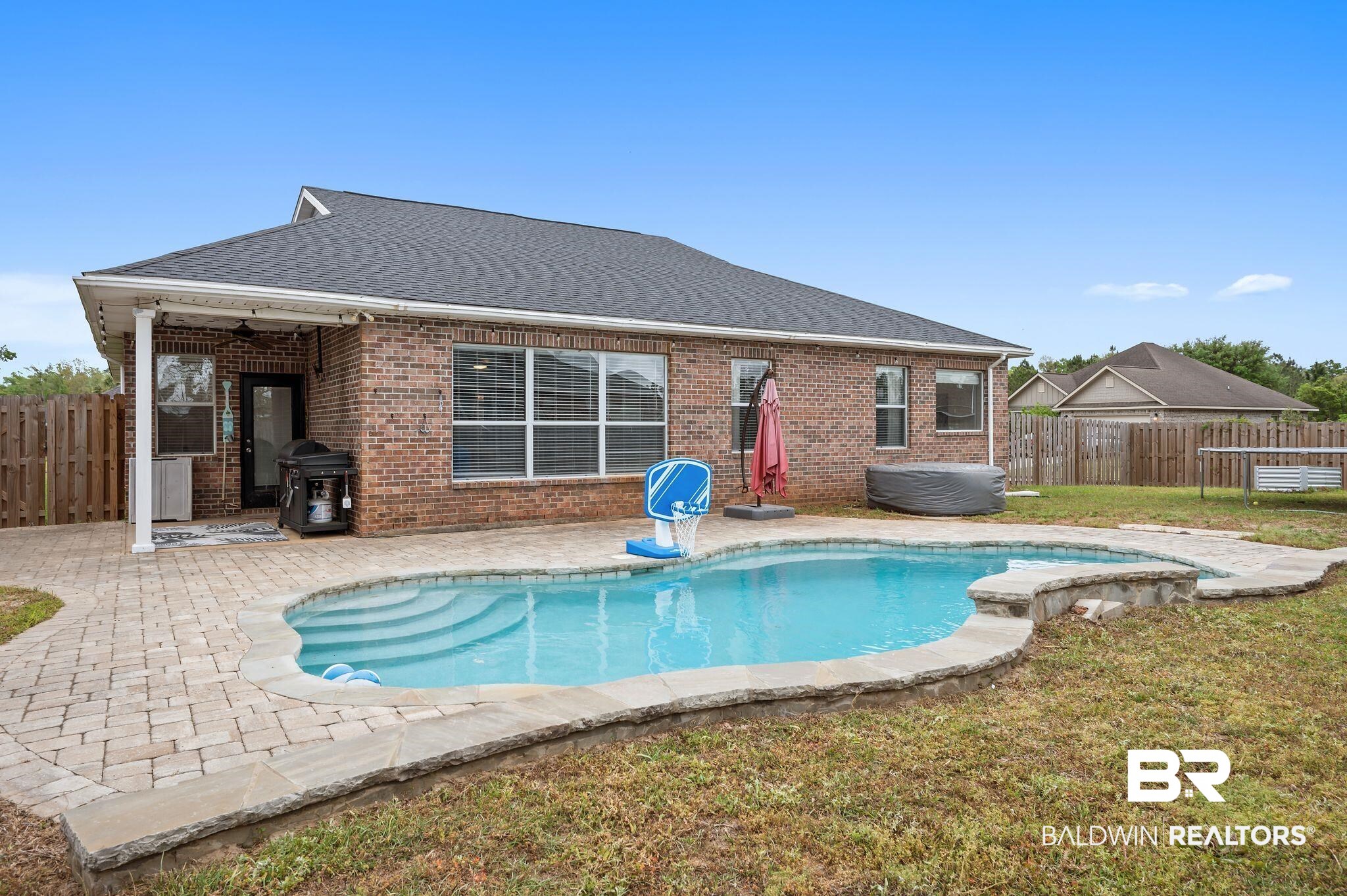 1287 Pembroke Way Foley, AL 36535 - Photo 36 of 39 Back of property with a fenced backyard, brick siding, roof with shingles, and a patio area