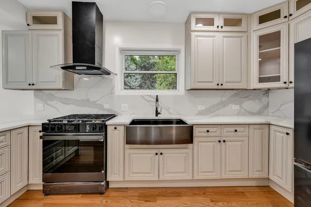 a kitchen with stainless steel appliances granite countertop white cabinets and a stove