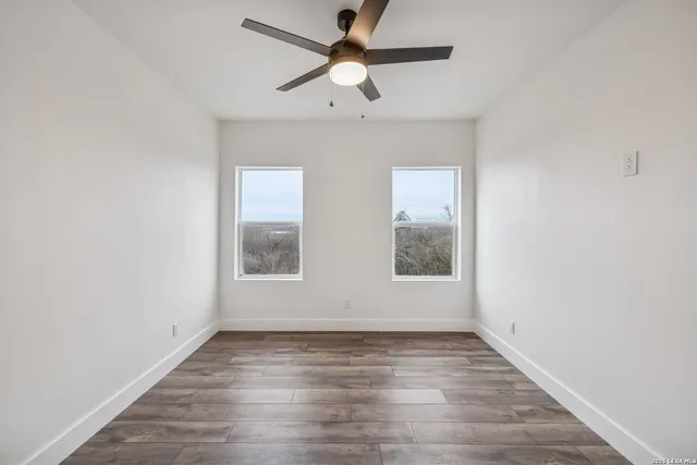 an empty room with a window and a fan
