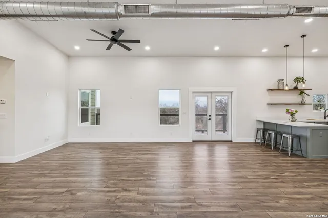 a view of an empty room with a window and wooden floor