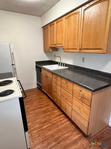 a kitchen with stainless steel appliances granite countertop a sink a stove and cabinets
