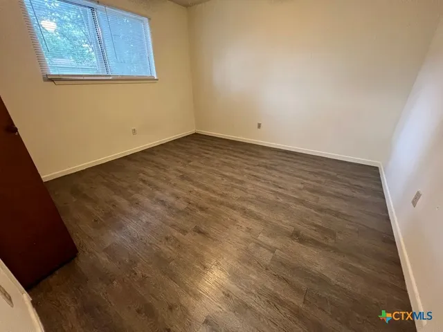 a view of a room with wooden floor