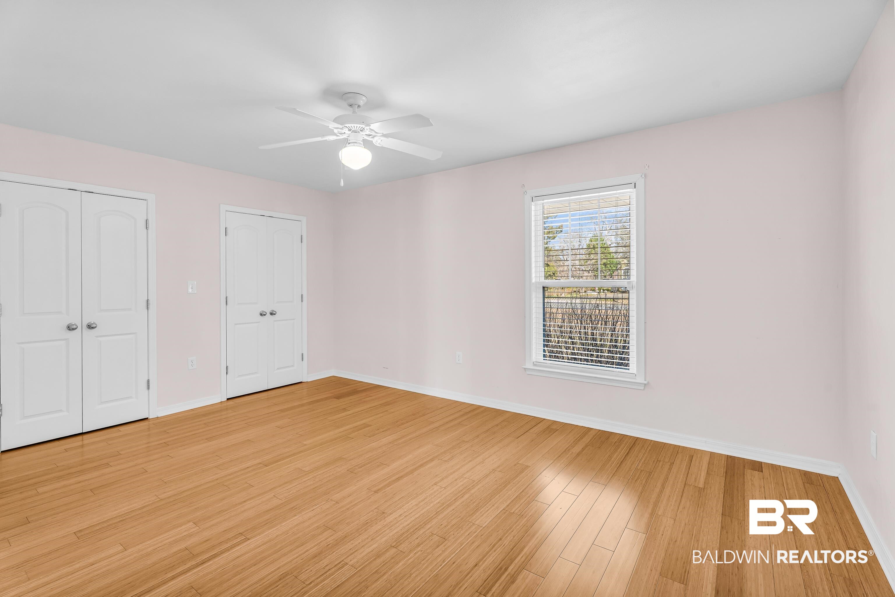 22095 8th Street Silverhill, AL 36576 - Photo 36 of 42 Unfurnished bedroom with multiple closets, ceiling fan, and light wood-type flooring