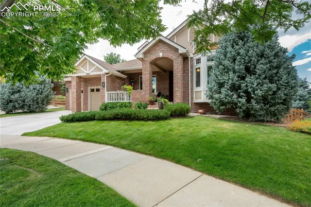 a front view of a house with a garden and yard