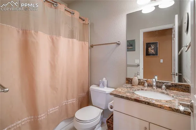 a view of a house with a wooden deck and a yard with furniture