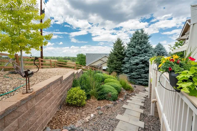 a view of a patio with table and chairs potted plants and a large tree