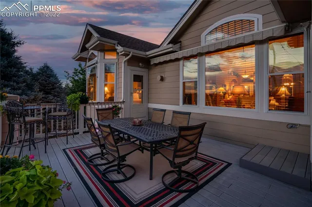 a view of a patio with table and chairs with wooden floor and fence
