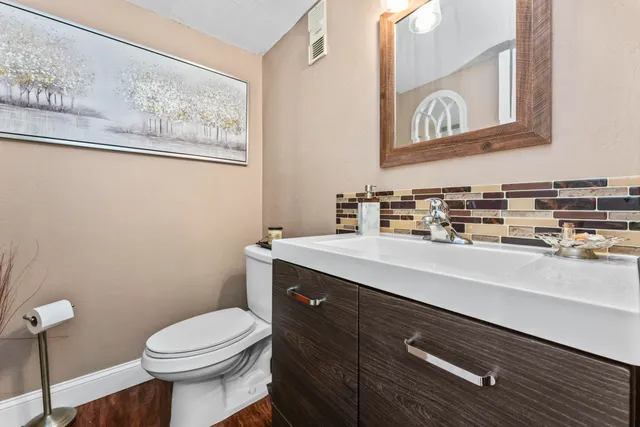 a bathroom with a toilet a sink and mirror