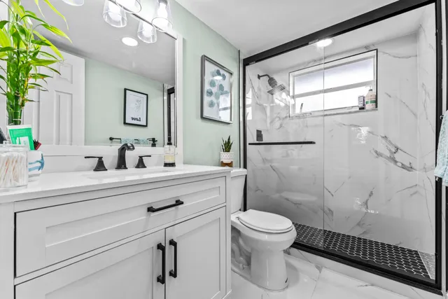 a bathroom with a sink a toilet and shower