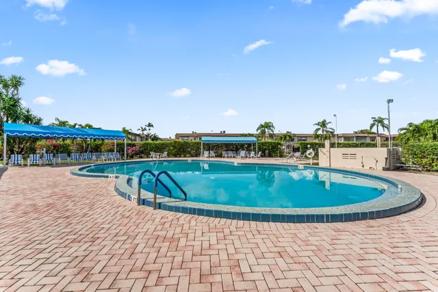 a view of swimming pool with outdoor seating and yard in the back