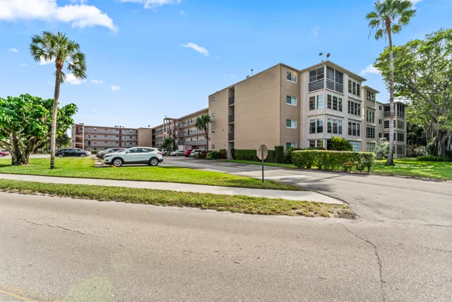a front view of a building with a garden and yard