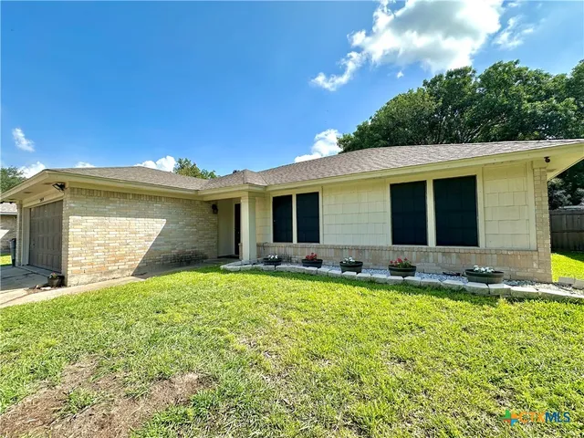 a view of a house with a yard and sitting area