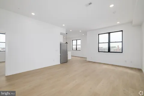 an empty room with windows and ceiling fan