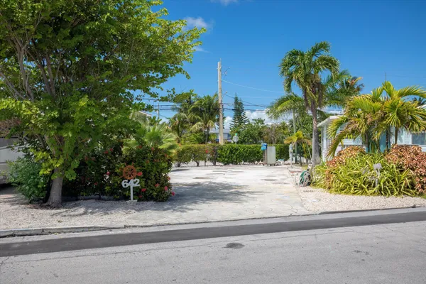 a view of a entrance gate of the house and trees