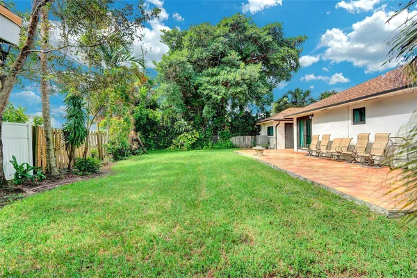 a front view of a house with a garden and trees