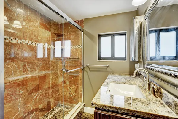 a bathroom with a granite countertop sink and a mirror