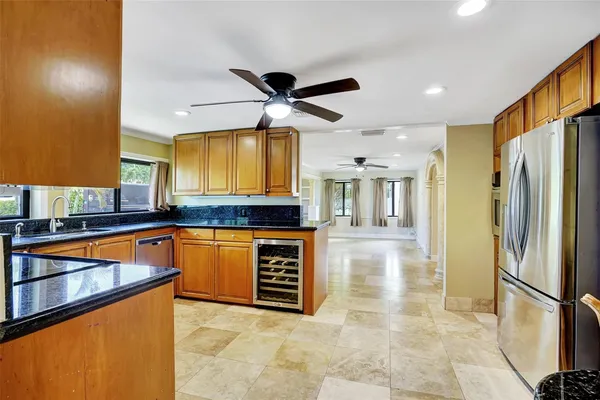 a kitchen with granite countertop a sink cabinets and stainless steel appliances