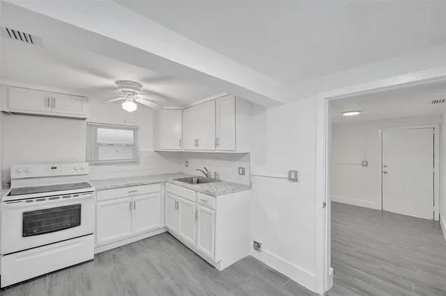 a kitchen with white cabinets and white appliances