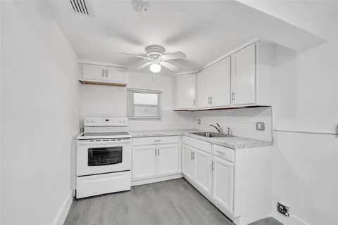 a kitchen with granite countertop white cabinets and white appliances