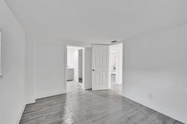 a view of an empty room with wooden floor
