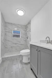 an empty room with wooden floor ceiling fan and window