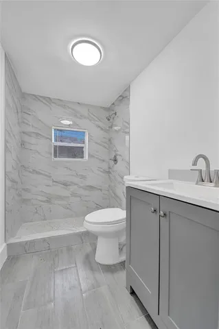 an empty room with wooden floor ceiling fan and window